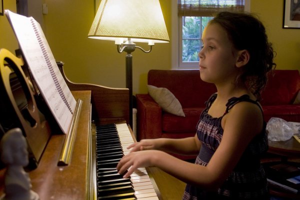 criança concentrada tocando piano